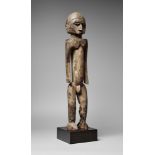 A LOBI MALE FIGURE With fine angular features and cap-like coiffure, the cubistic body with