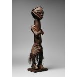 A MBALA FIGURE Standing with the arms held forward, raffia apron about the waist, dark patina. 55