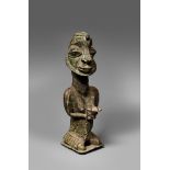 A YORUBA ONILE FIGURE The kneeling female holding before her in both hands a bowl containing a