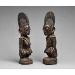 A PAIR OF YORUBA TWIN FIGURES Male and female, each with tall hatched coiffure with median ridge,