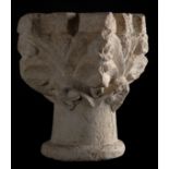 Limestone capital resting on the base of a column, sculpted with fleurs de lys, leaves and