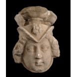 Limestone wall mount sculpted on one side and depicting a woman’s head with a headdress decorated