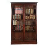 AN EARLY 19TH CENTURY MAHOGANY TWO DOOR BOOKCASE The dentil moulded pediment... AN EARLY 19TH