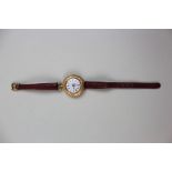 Ladies 18ct Gold Wrist watch on a leather strap, floral enamel face with Roman numerals