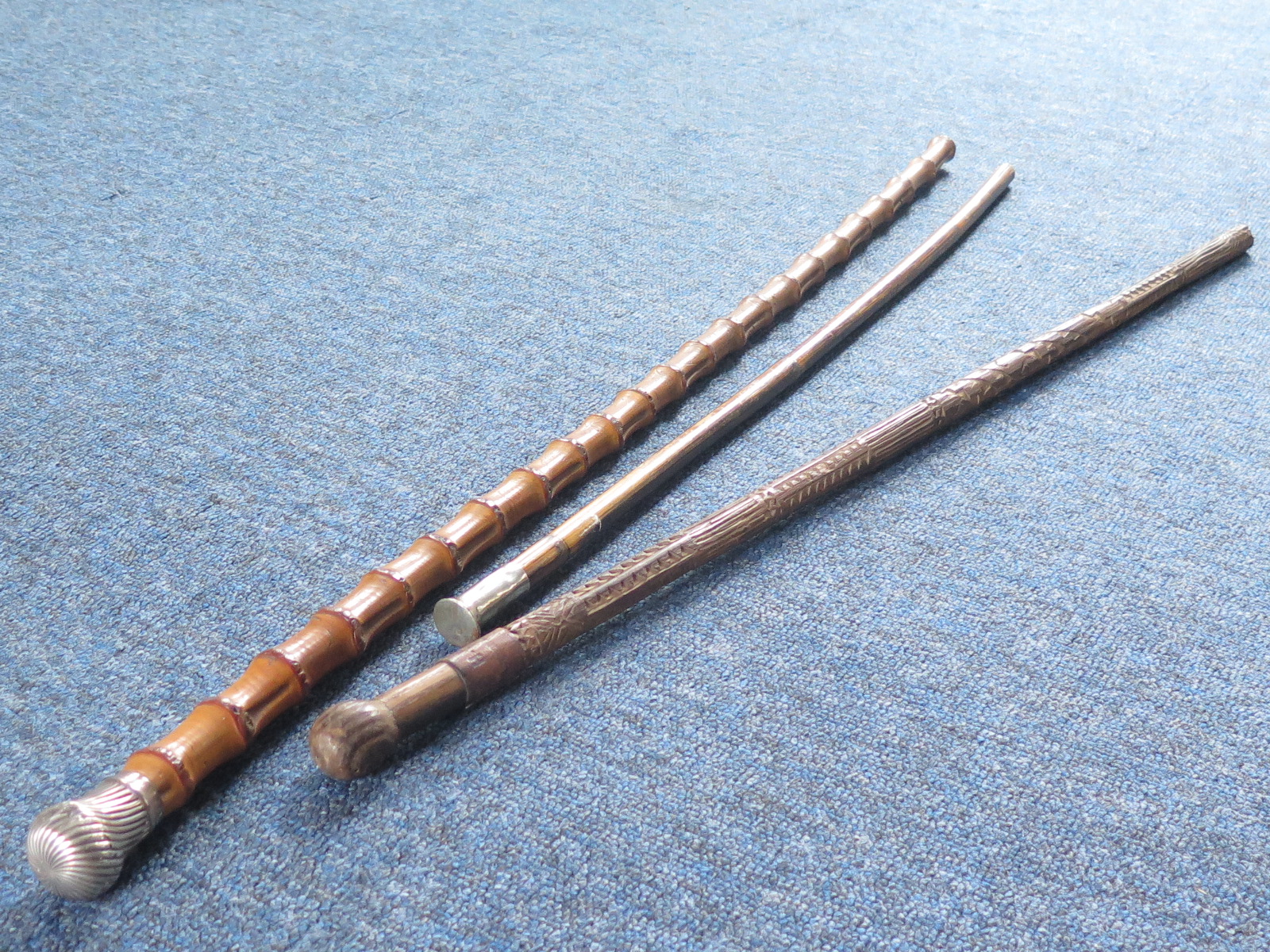 Walking sticks inc a German carved WW2 era stick, R.W.F. long swagger stick and a silver toped
