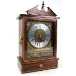 A walnut veneered early 20th century mantle clock with an eight day movement striking on a gong.