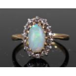 Yellow metal ring marked 18ct set with central opal surrounded by diamonds size K weight 2.8 grams