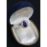 White metal ring marked Plat set with large central oval Sapphire and surrounded by diamonds size P