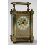 Early 20th century brass carriage clock with gilt chapter ring and archetectural styling.