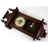 American wall clock of architectural form with pendulum and key included.