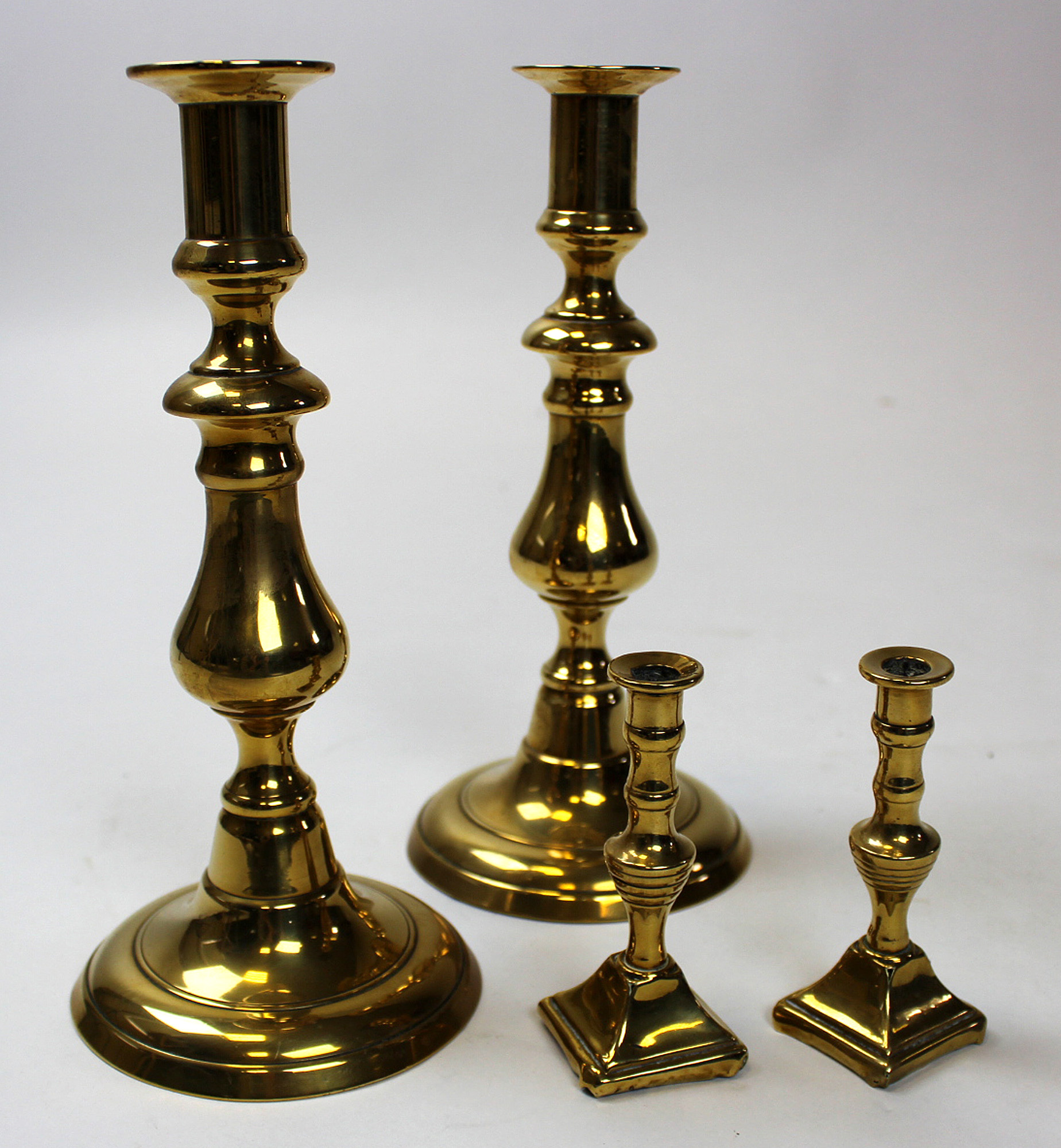 Two pairs of 19th century brass candlesticks one being 23 cm high and fitted with ejectors and the