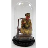 Exquisitly carved and painted Chinese figure of a seated man under a glass dome, on a wooden stand