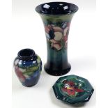 Three pieces of Moorcroft pottery, comprising an octagonal ashtray depicting an orchid, a small blue