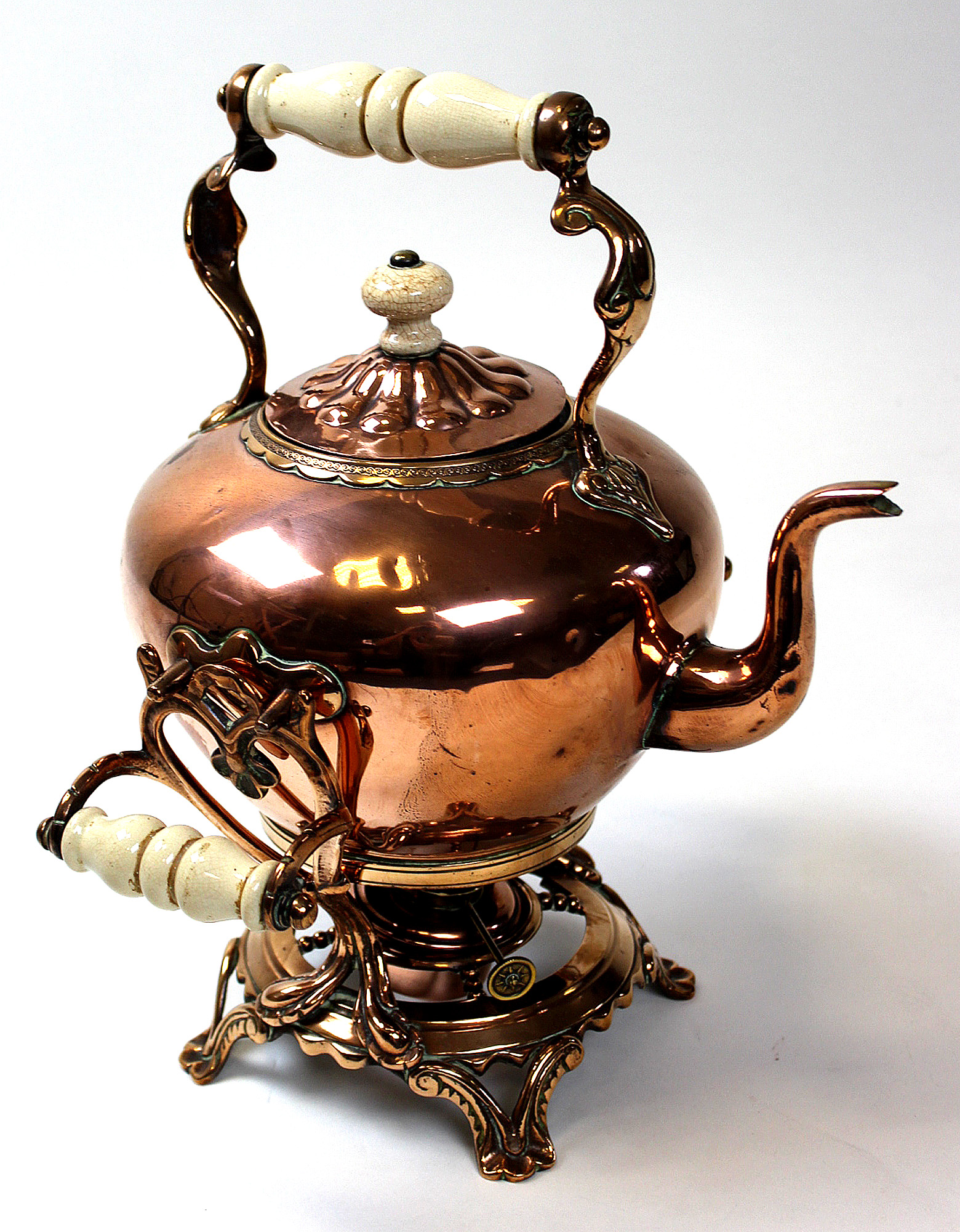 A Victorian Copper Kettle on stand with burner, ceramic handles and ornate scrolled decoration.