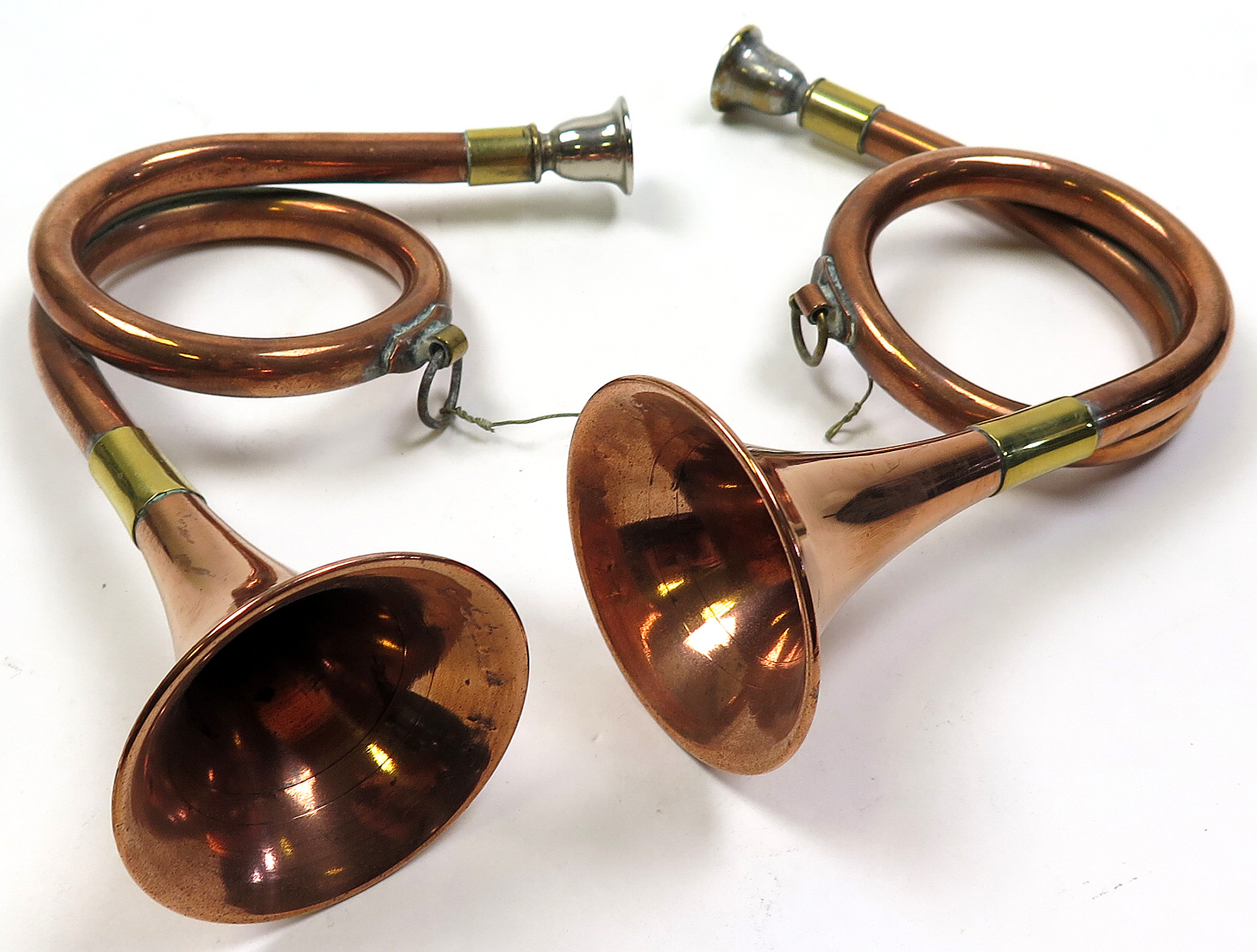 Pair of Victorian copper hunting horns with silvered brass mouth pieces and brass fittings. Each