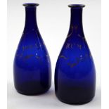 A pair of 18th century Bristol blue glass decanters decorated in gilt writing Rum and Hollands on