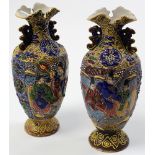 A pair of early 20th century Japanese porcelain vases with textured detail and tubelined decoration.