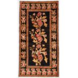 Caucasian Rug: 4'1" x 7'10" (124 x 239 cm) early 20th c.,  large floral sprays on a black field.