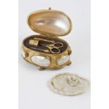 Small oval box in golden metal for sewing accessories. Mother-of-pearl lid and elements on the box’s