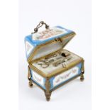 Rare sewing box in the shape of a casket with a golden metal structure. It rests on four feet and