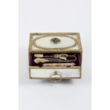 Mother-of-pearl and golden bronze box on feet with central drawer which contains 5 sewing tools in