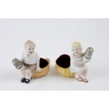 Couple of porcelain children with thimble holders and needle and pin cushions. H: 8.5 cm, L: 8 cm,