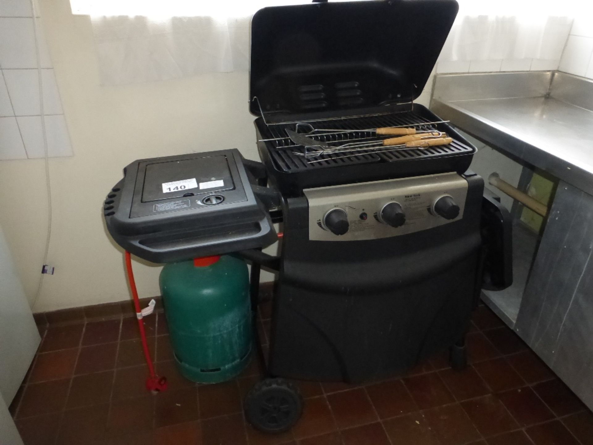 1 Newyork mobile three burner gas barbeque with side burner and various utensils (located in kitchen