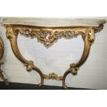 NV- A decorative gilt work consul table with two supports and a mottled shaped marble top