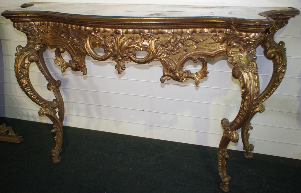 NV- A very decorative gilt work consul table with four shaped supports, a fretwork and foliate