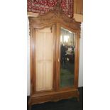 NV- A highly decorative carved mahogany French style armoire/wardrobe with two mirrored doors (one