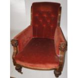 NV- A carved mahogany armchair with lion mask hand holds and rust coloured buttoned upholstery
