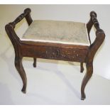 NV- A carved mahogany music stool with side handles and a lift seat