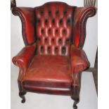 NV- A dark red coloured buttoned leather wing-back armchair