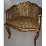 NV- A gilt decorated French style armchair with an upholstered seat and a bergere back