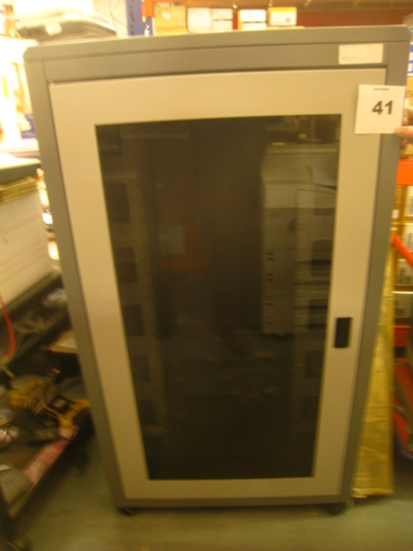Substantial freestanding comms cabinet in very clean condition on wheels  with clear front door.