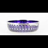 Circular pierced silver-plated fruits dish. Side handles enhanced with gadroons. Blue glass liner