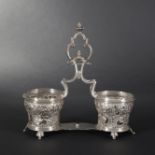 Silver oil and vinegar cruet stand atop six small foliaged feet. Pierced decoration of Rococo