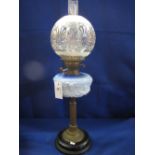 Brass double burner oil lamp with relief decorated ceramic reservoir on a brass pedestal with