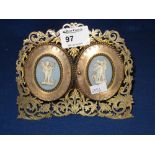 19th century brass double photograph frame with hinged covers having jasper ware cherub mounts.