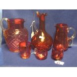 6 items of cranberry glass to include baluster shaped dimple jug with reeded handle, mallet shaped