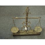 Pair of decorative wrought iron scales on wooden base.