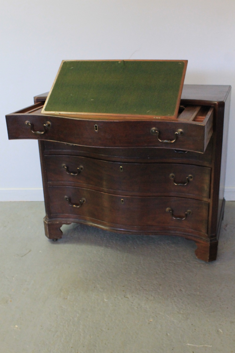 18th CENTURY MAHOGANY SERPENTINE FRONTED FITTED BACHELOR'S CHEST OF FOUR GRADUATED DRAWERS, having