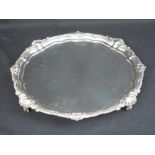 MODERN OCTAGONAL SILVER SALVER with stepped scroll and shell decorated rim raised on four scrolled