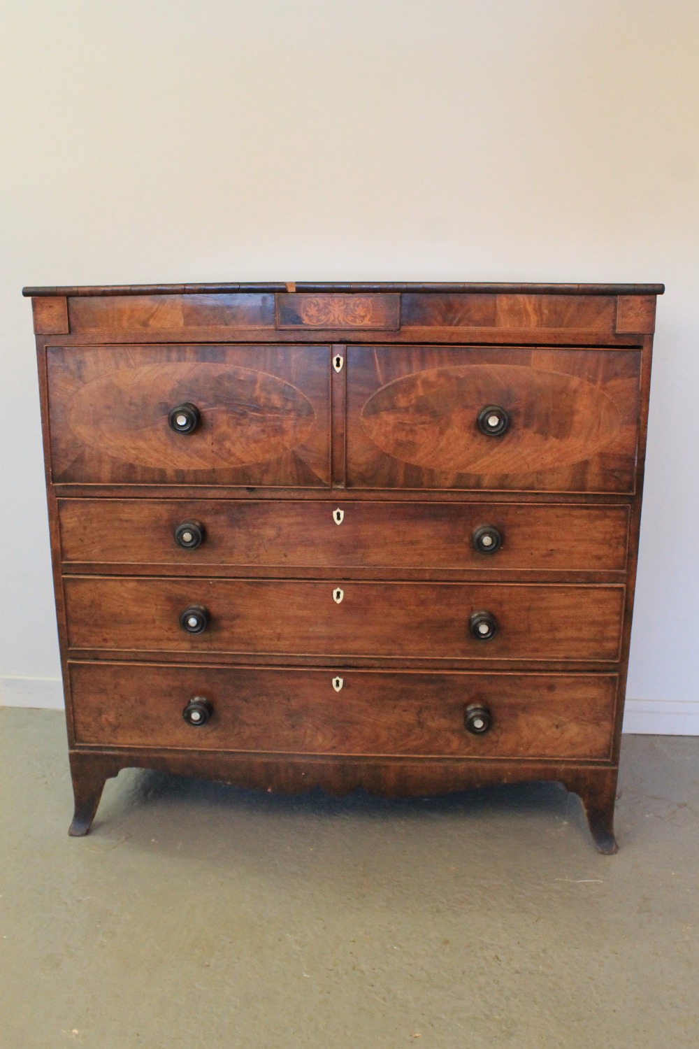 EARLY 19th CENTURY MAHOGANY SECRETAIRE CHEST OF DRAWERS having moulded edge top above foliate inlaid