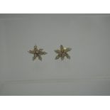 A PAIR OF 18CT GOLD AND DIAMOND EARRINGS.  Designed to depict a star shaped flower, each petal set