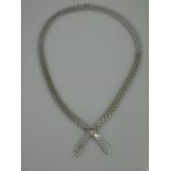 AN 18CT WHITE GOLD NECKLACE OF FLAT POLISHED LINKS WITH STYLISED BOW DETAIL.  Length 16 inches (41