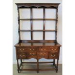 SMALL GEORGIAN STYLE OAK DRESSER having open rack back over projecting base with an arrangement of