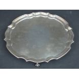 ELIZABETH II SILVER CIRCULAR PIECRUST EDGE SALVER raised on four scroll feet.  Birmingham, 1952.