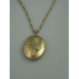 A LARGE 9CT GOLD OVAL ENGRAVED PHOTOGRAPH LOCKET.  The front engraved with scrolling foliage.  2"