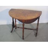 VICTORIAN WALNUT OVAL DROP LEAF SUTHERLAND TABLE having pierced lyre shaped ends and baluster turned